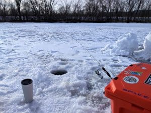 ice fishing with hard sided cooler, line in ice hole, using abu garcia ice fishing rod and reel