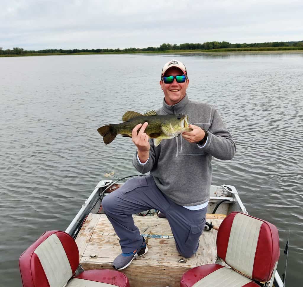 fall bass fishing. man holding 5lb bass caught in the fall on the mississippi river