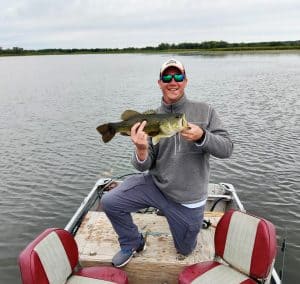 fall bass fishing tips. man holding 5lb bass caught in the fall on the mississippi river