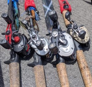 4 baitcaster reels setup for bass fishing laying on boat