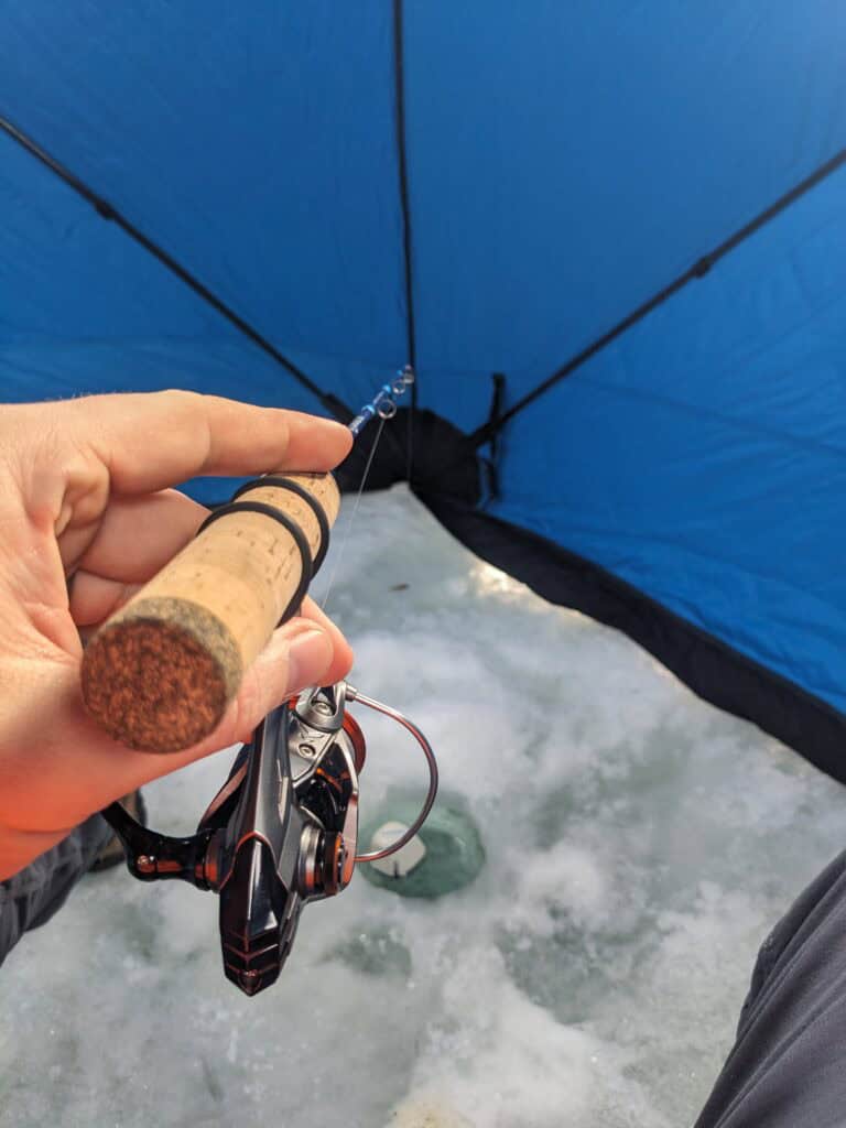 KastKing Kestrel ice fishing reel and rod used inside a ice fishing popup